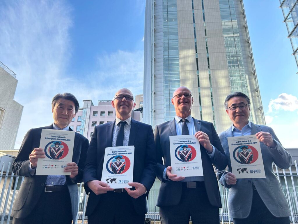 Photo représentant les responsables du colloque en train de tenir l'affiche de celui-ci dans leurs mains, au Japon