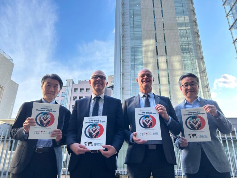 Photo représentant les responsables du colloque en train de tenir l'affiche de celui-ci dans leurs mains, au Japon